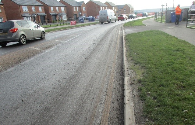 mud on a busy road in a built up residental area